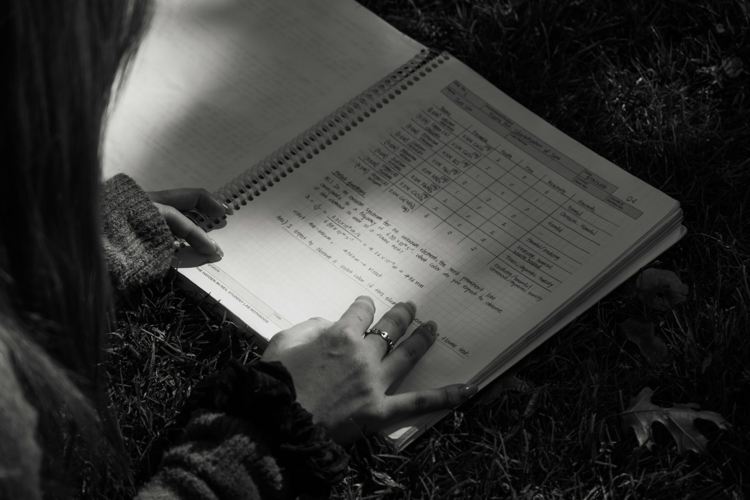 ノートに指を添えて読み込む手元